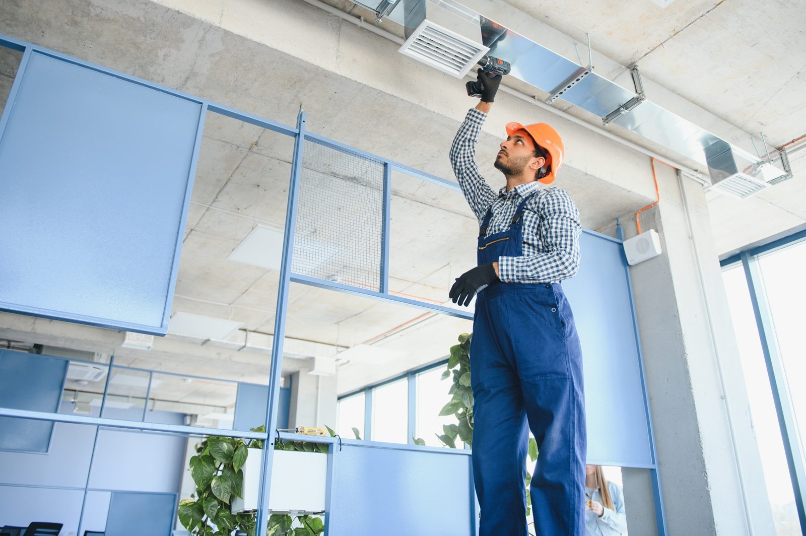 Maintenance technician servicing a ceiling vent